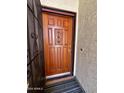 Beautiful wood front door with decorative details and a secure view at 6845 W Caron Dr, Peoria, AZ 85345