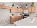 Functional kitchen featuring light wood cabinetry, a stainless steel stove, and a white countertop with a sink at 8802 E University Dr # 28, Mesa, AZ 85207