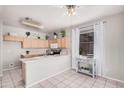 Bright kitchen area with light-toned cabinets, a stainless steel microwave, and a large window for natural light at 8802 E University Dr # 28, Mesa, AZ 85207