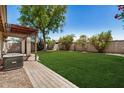 Well-maintained backyard with lush green grass and a charming pergola, ideal for outdoor enjoyment at 9135 W Hazelwood St, Phoenix, AZ 85037