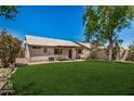 Spacious backyard with a well-kept lawn and a view of the home's exterior at 9135 W Hazelwood St, Phoenix, AZ 85037