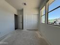 Bright bedroom with large window and closet with sliding doors; freshly painted and ready at 9532 W Parkway Dr, Tolleson, AZ 85353
