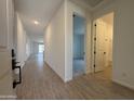 Bright hallway with wood-look flooring leading to a bathroom and bedrooms at 9544 W Parkway Dr, Tolleson, AZ 85353
