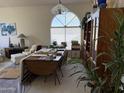 Bright living room featuring vaulted ceilings and a large arched window allowing natural light at 12955 E Sahuaro Dr, Scottsdale, AZ 85259