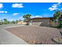 Tan brick home with desert landscaping and a covered carport at 1307 E Broadmor Dr, Tempe, AZ 85282