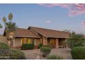 Inviting home with desert landscaping, mature bushes, and charming brick accents at 15849 N 46Th Pl, Phoenix, AZ 85032