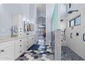 Bright bathroom with a dual sink vanity, hexagon tile floor, and walk-in shower at 16396 W Fillmore St, Goodyear, AZ 85338