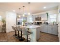 Modern kitchen with gray cabinets, stainless steel appliances, and a granite island with seating at 16425 W Latham St, Goodyear, AZ 85338