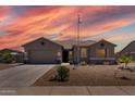 Charming single-story home showcasing desert landscaping, a spacious driveway, and a welcoming facade with a prominent American flag at 18319 W Marshall Ave, Litchfield Park, AZ 85340