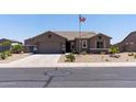 Well-maintained home featuring desert landscaping, a two-car garage, and patriotic American flag in a quiet neighborhood at 18319 W Marshall Ave, Litchfield Park, AZ 85340