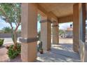 A view of the covered porch with decorative columns and landscaped garden at 19321 N Tara Lane Ln, Maricopa, AZ 85138