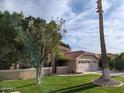 Charming home featuring a spacious garage, green lawn, mature trees, and a red tile roof at 2955 E Hermosa Vista Dr, Mesa, AZ 85213