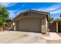 Home featuring a two-car garage, mature landscaping, and a well-maintained driveway at 42277 W Chisholm Dr, Maricopa, AZ 85138