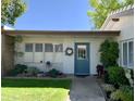 A cozy single-story home with lush landscaping, including a blue door and well-manicured lawn at 4800 N 68Th St # 164, Scottsdale, AZ 85251
