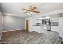 Open-concept living space with sleek floors flowing into a bright kitchen with white cabinetry at 500 E Hermosa Dr, Tempe, AZ 85282