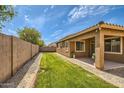 View of backyard featuring grass, a block wall, and a covered patio at 6815 W Carter Rd, Laveen, AZ 85339