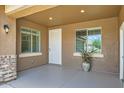 Inviting covered front porch with decorative brick accents, neutral paint, and stylish lighting fixture at 6815 W Carter Rd, Laveen, AZ 85339