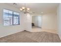 Comfortable living room featuring plush carpeting, a modern light fixture, and neutral paint at 6815 W Carter Rd, Laveen, AZ 85339