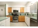 Well-lit kitchen with light countertops, wood and white cabinets, and stainless steel appliances at 6936 E 4Th St # 5, Scottsdale, AZ 85251