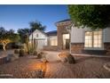 Gorgeous home featuring stone accents, desert landscaping, and a charming brick pathway leading to the entrance at 7590 W Firebird Dr, Glendale, AZ 85308