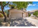 Charming two-story home featuring a well-manicured front yard, and a three-car garage with desert landscaping at 7758 E Nestling Way, Scottsdale, AZ 85255