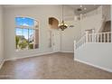 Grand foyer featuring soaring ceilings, large window, tile floors, and staircase to the second floor at 7758 E Nestling Way, Scottsdale, AZ 85255