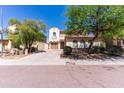 Charming two-story home showcasing its manicured front yard with mature trees enhancing its curb appeal under a bright blue sky at 7925 S 52Nd Dr, Laveen, AZ 85339