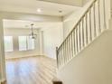 Bright living room featuring wood-look floors, staircase, and modern light fixture at 7925 S 52Nd Dr, Laveen, AZ 85339