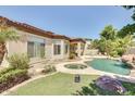 Beautiful backyard featuring a pool, spa, lush landscaping, and a covered patio perfect for outdoor living at 795 W Verbena Ln, Litchfield Park, AZ 85340