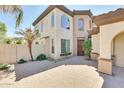 Inviting front entrance with a paver walkway, a mature palm tree, and a solid wood front door with sidelights at 795 W Verbena Ln, Litchfield Park, AZ 85340
