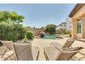 Relaxing pool area with a rock waterfall, lounge chairs, and lush tropical landscaping creating a private oasis at 795 W Verbena Ln, Litchfield Park, AZ 85340