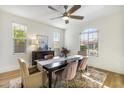 Bright dining room with modern chandelier, large window, hardwood floors, and stylish table setting at 831 E Tonto Pl, Chandler, AZ 85249