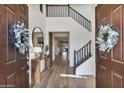 Spacious foyer with high ceilings, wood floors, a staircase, and decorative wreaths on the entry doors at 831 E Tonto Pl, Chandler, AZ 85249