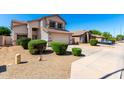 Lovely two-story home featuring a spacious driveway, two-car garage and manicured bushes at 8755 E Portobello Ave, Mesa, AZ 85212