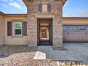 Inviting front entryway with a decorative security gate, stone facade, and a well-manicured pebble yard at 9253 W Sands Dr, Peoria, AZ 85383