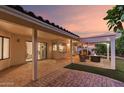 Spacious covered patio with an outdoor kitchen, ample seating around a fire pit, and direct access to the home at 9809 W Behrend Dr, Peoria, AZ 85382