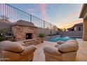 Cozy outdoor area featuring a stone fireplace and comfortable seating near the pool at 9847 E Preserve Way, Scottsdale, AZ 85262
