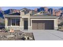 A beautiful single-story home with a two car garage, desert landscaping, and mountain views at 10524 W Bloch Rd, Tolleson, AZ 85353