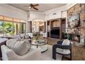 Spacious living room with a stone fireplace, custom built-ins, and access to the outdoor patio at 11717 E Estrella Ave, Scottsdale, AZ 85259