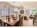 Bright dining room with decorative chandelier, hardwood table, and views of the living room at 17874 N 93Rd Way, Scottsdale, AZ 85255