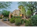 Charming home with desert landscaping, featuring a unique turret design and a welcoming entrance at 18283 N 93Rd St, Scottsdale, AZ 85255