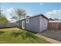 View of the side yard and backyard featuring artificial turf and a well-maintained exterior at 2118 E Oak St, Phoenix, AZ 85006