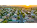 Beautiful aerial view of neighborhood with rows of houses, green trees and landscaping, and distant mountains at 2533 W Novak Way, Phoenix, AZ 85041