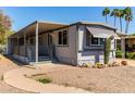 Cozy gray home with a covered porch, desert landscaping and adjacent covered parking area at 2650 W Union Hills Dr # 29, Phoenix, AZ 85027