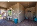 Cozy front porch with rocking chairs, textured walls, and a stylish front door, creating a welcoming entrance at 29403 N 119Th Ln, Peoria, AZ 85383