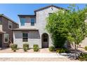 Charming two-story home featuring a textured facade, arched entryway, and well-maintained desert landscaping at 302 N 69Th Pl, Mesa, AZ 85207