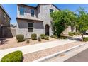 Charming two-story home featuring a textured facade, arched entryway, and well-maintained desert landscaping at 302 N 69Th Pl, Mesa, AZ 85207