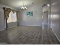 Open living room with wood-look tile floors, chandelier, and abundant natural light at 4255 E Rock Dr, San Tan Valley, AZ 85143