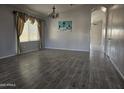 Open living room with wood-look tile floors, chandelier, and abundant natural light at 4255 E Rock Dr, San Tan Valley, AZ 85143