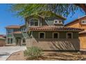 Two-story home with a lovely two-tone green exterior, a red tile roof, and large picture windows at 45080 W Buckhorn Trl, Maricopa, AZ 85139